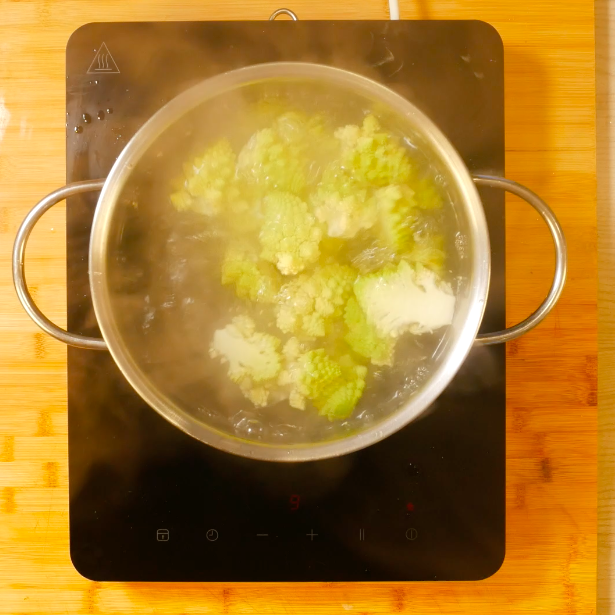 Sbollentare il broccolo romanesco in acqua bollente.